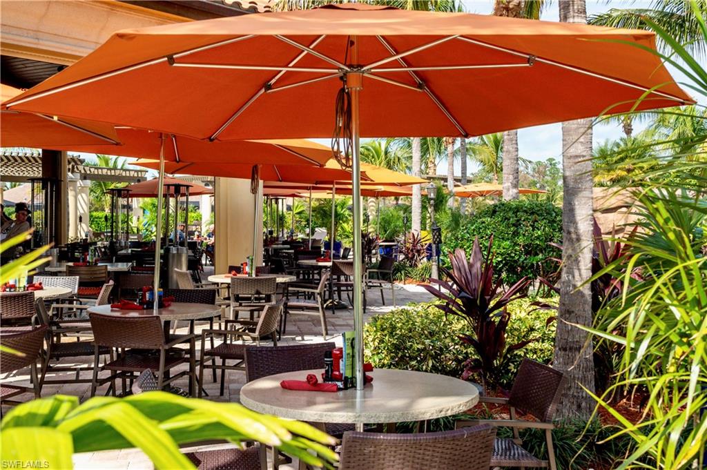 9834 Giaveno Circle, Unit 1746 Naples, FL 34113 - Photo 33 of 41 an outdoor space with furniture and umbrella