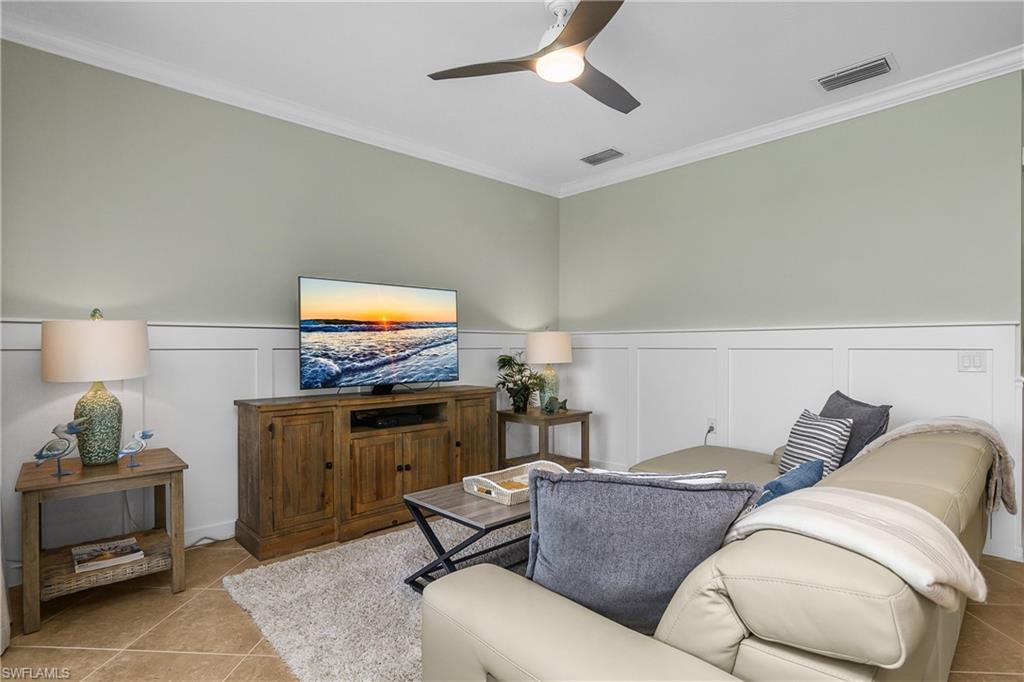 9834 Giaveno Circle, Unit 1746 Naples, FL 34113 - Photo 5 of 41 a living room with furniture and a flat screen tv