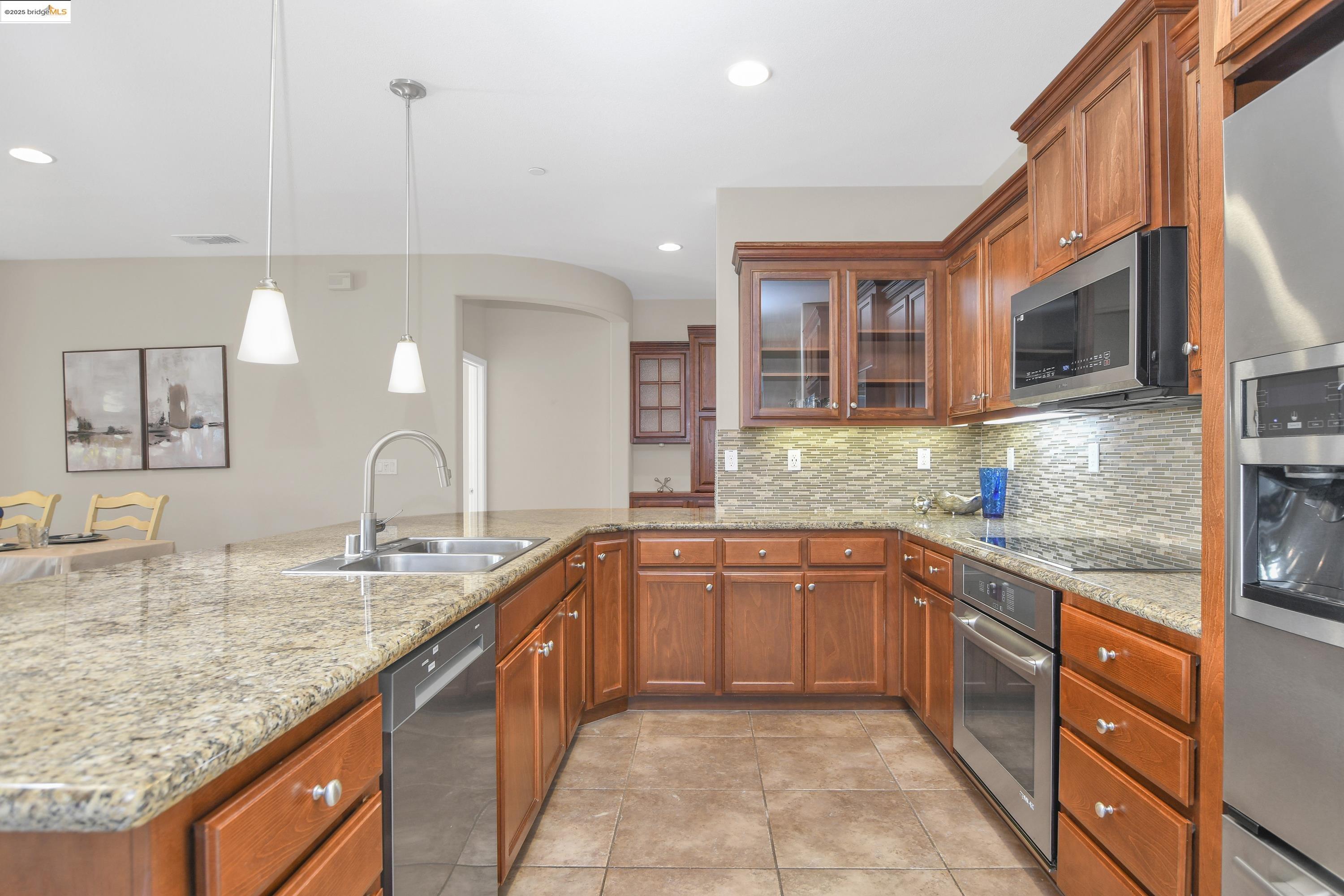 353 Desert Forest Court Rio Vista, CA 94571 - Photo 18 of 39 a kitchen with stainless steel appliances granite countertop a sink and dishwasher a stove top oven with wooden floor