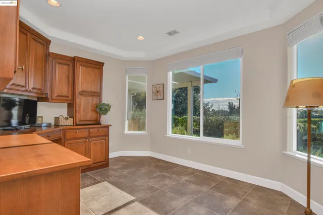 a kitchen with granite countertop a refrigerator a stove top oven and cabinets