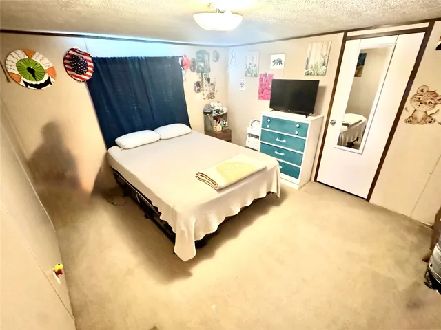 a spacious bedroom with a bed and a flat screen tv