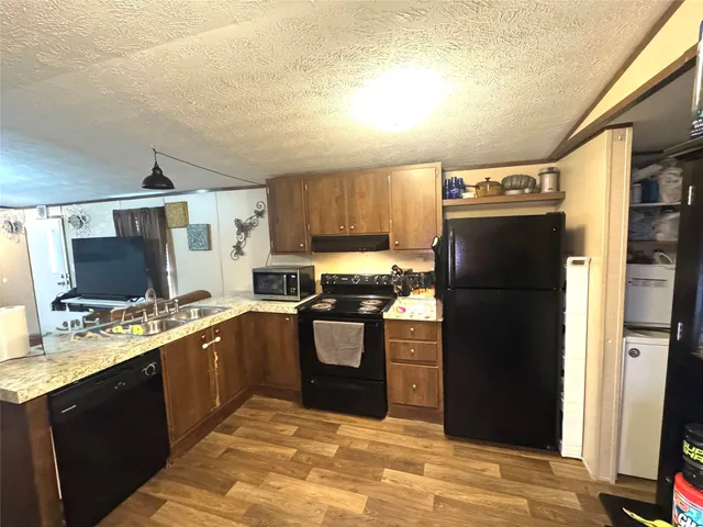 a kitchen with stainless steel appliances granite countertop a refrigerator a sink and a stove