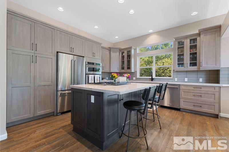 3521 South Cheechako Circle Reno, NV 89519 - Photo 13 of 40 a kitchen with stainless steel appliances granite countertop a refrigerator a sink dishwasher a stove and a refrigerator with wooden floor