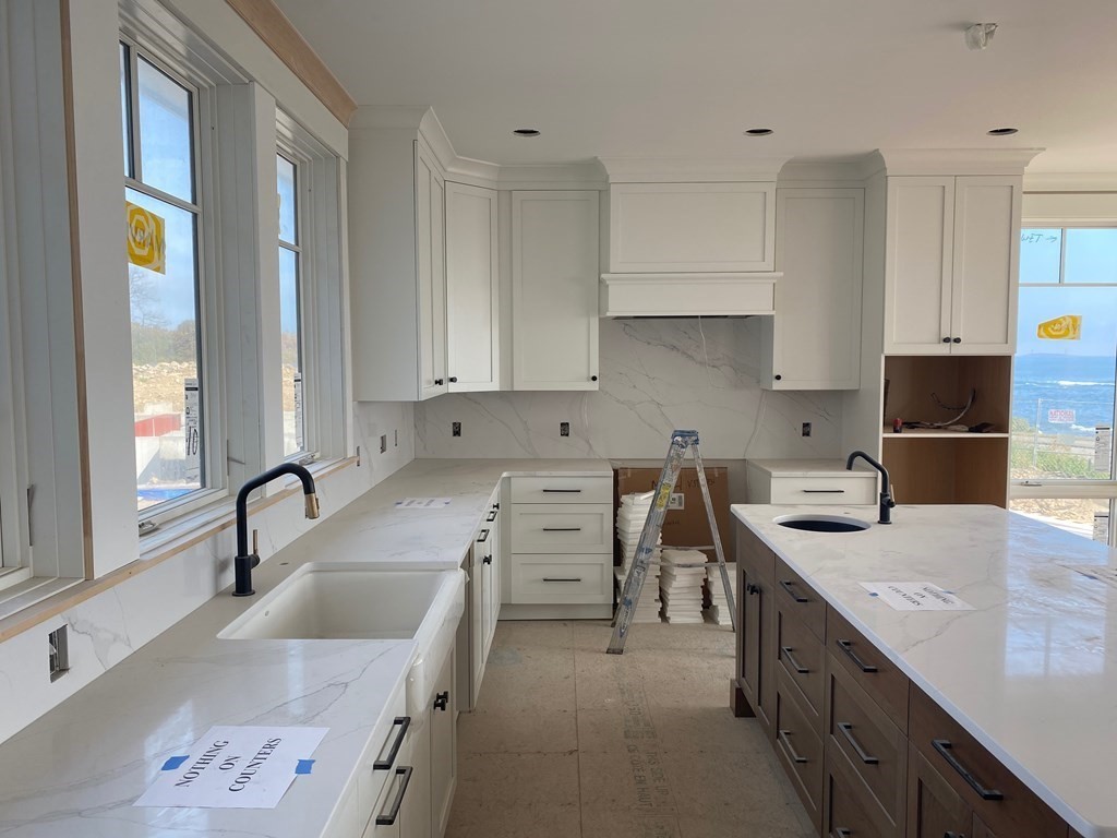 169 Atlantic Road Gloucester, MA 01930 - Photo 8 of 24 a kitchen with stainless steel appliances granite countertop a sink stove and cabinets