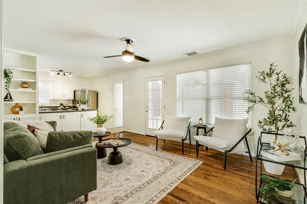 700 Ridgedale Drive Richardson, TX 75080 - Photo 11 of 32 This versatile second living space features warm hardwood floors and a modern ceiling fan, offering a cozy seating arrangement that flows naturally into the open-concept kitchen.