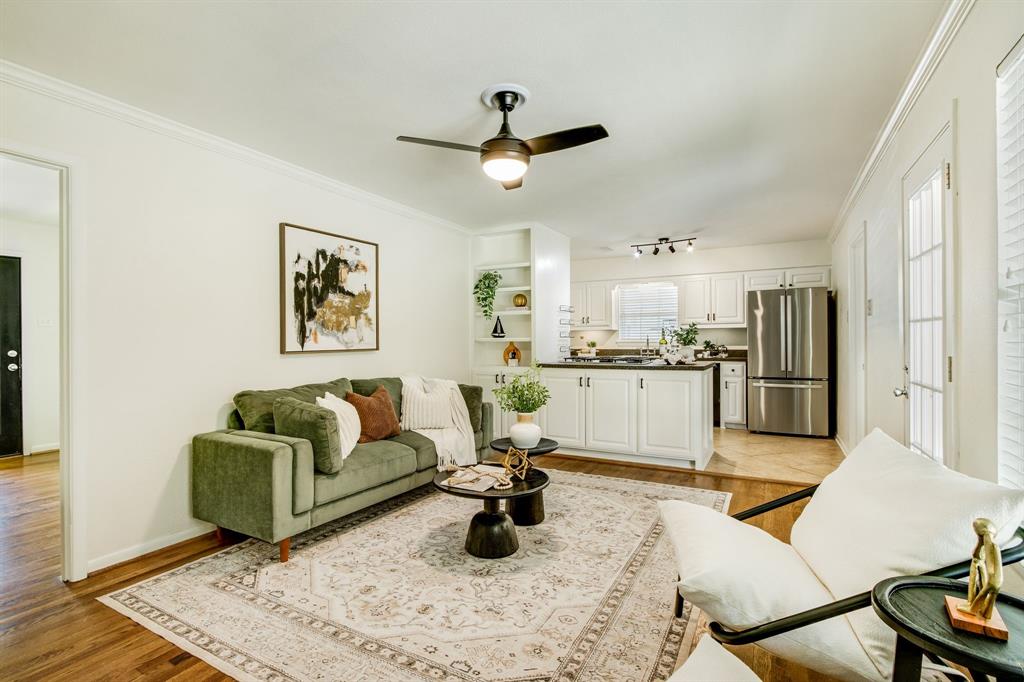 700 Ridgedale Drive Richardson, TX 75080 - Photo 12 of 32 This versatile second living space features warm hardwood floors and a modern ceiling fan, offering a cozy seating arrangement that flows naturally into the open-concept kitchen.