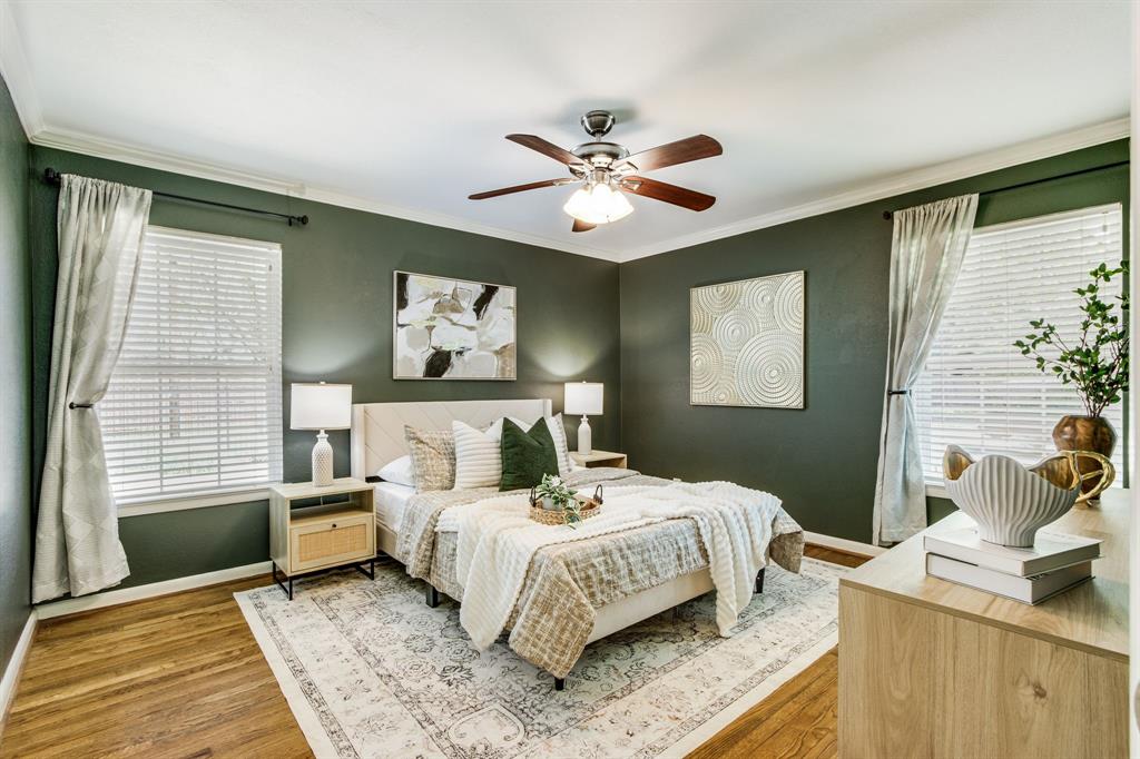 700 Ridgedale Drive Richardson, TX 75080 - Photo 18 of 32 The sophisticated primary suite showcases deep sage green walls, warm hardwood floors, and a modern ceiling fan, creating a serene retreat.