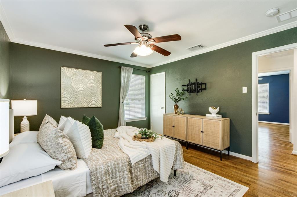 700 Ridgedale Drive Richardson, TX 75080 - Photo 19 of 32 The sophisticated primary suite showcases deep sage green walls, warm hardwood floors, and a modern ceiling fan, creating a serene retreat.