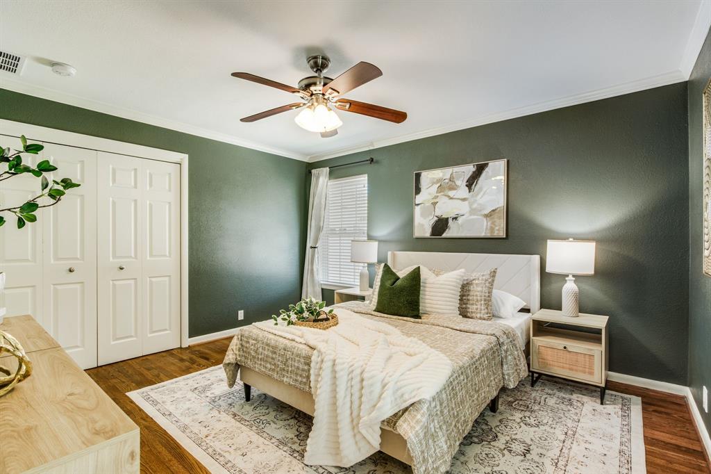 700 Ridgedale Drive Richardson, TX 75080 - Photo 20 of 32 The sophisticated primary suite showcases deep sage green walls, warm hardwood floors, and a modern ceiling fan, creating a serene retreat.