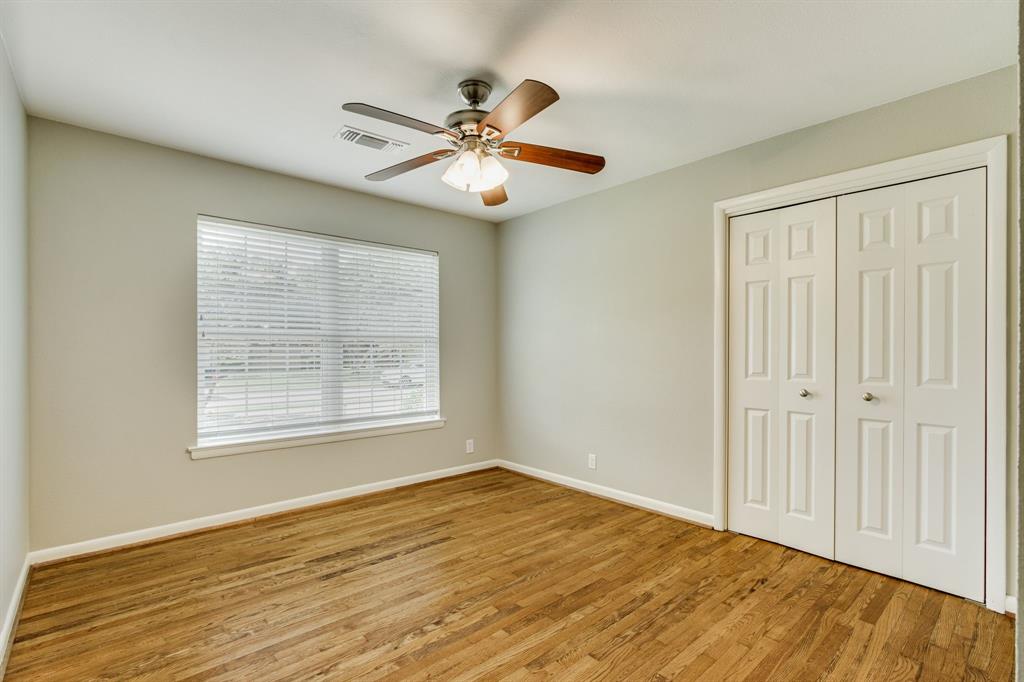 700 Ridgedale Drive Richardson, TX 75080 - Photo 23 of 32 Secondary bedroom with large windows and a ceiling fan.