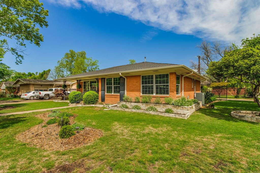 700 Ridgedale Drive Richardson, TX 75080 - Photo 3 of 32 A classic brick ranch-style home features large windows with decorative black iron security screens and shutters, framed by well-maintained landscaping with large front yard.