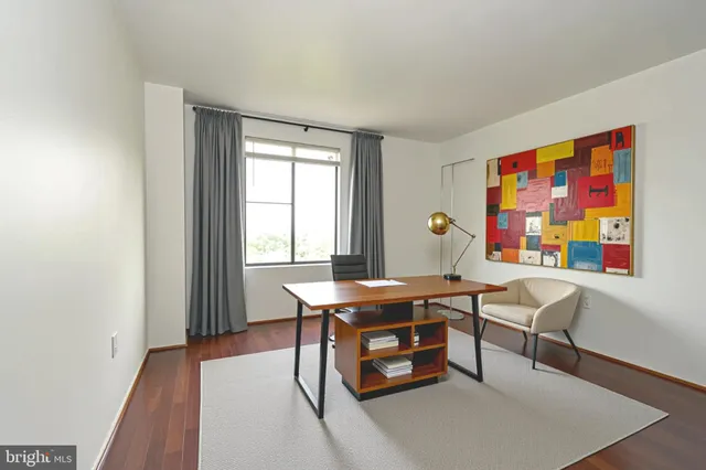 a view of a workspace with furniture and window