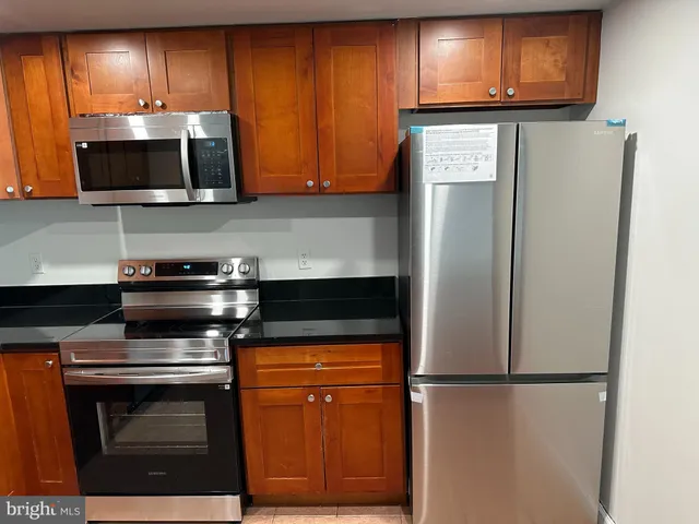 a kitchen with stainless steel appliances wooden cabinets and a stove top oven