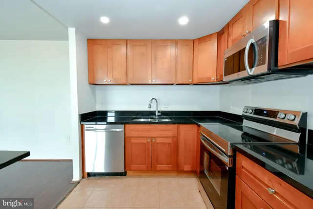 a kitchen with stainless steel appliances granite countertop a sink and a stove top oven