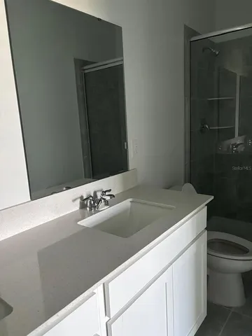 a bathroom with a sink vanity and toilet