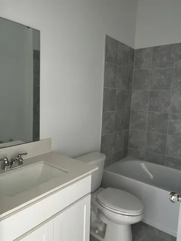 a view of empty room with kitchen and window