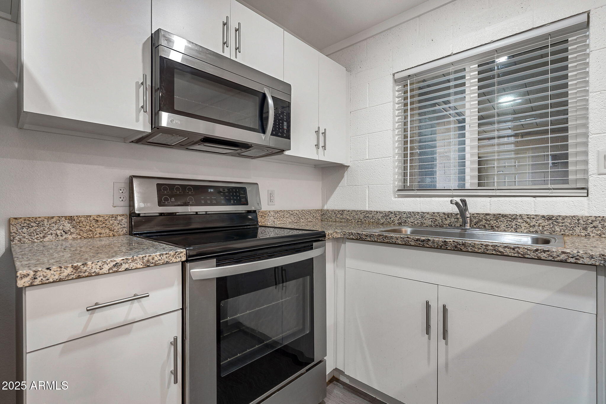 622 North 9th Avenue, Unit 101 Phoenix, AZ 85007 - Photo 11 of 18 a kitchen with granite countertop a sink cabinets and stainless steel appliances