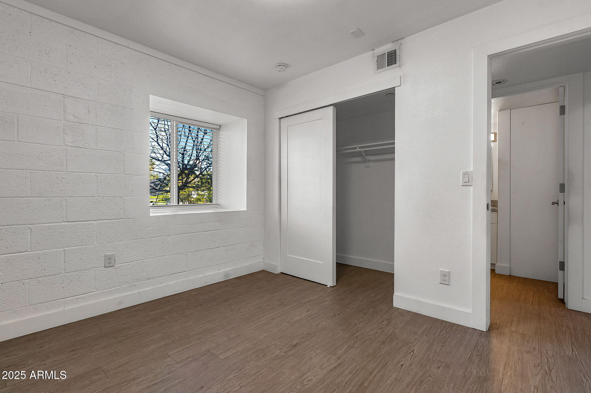 622 North 9th Avenue, Unit 101 Phoenix, AZ 85007 - Photo 13 of 18 a view of an empty room with wooden floor and a window