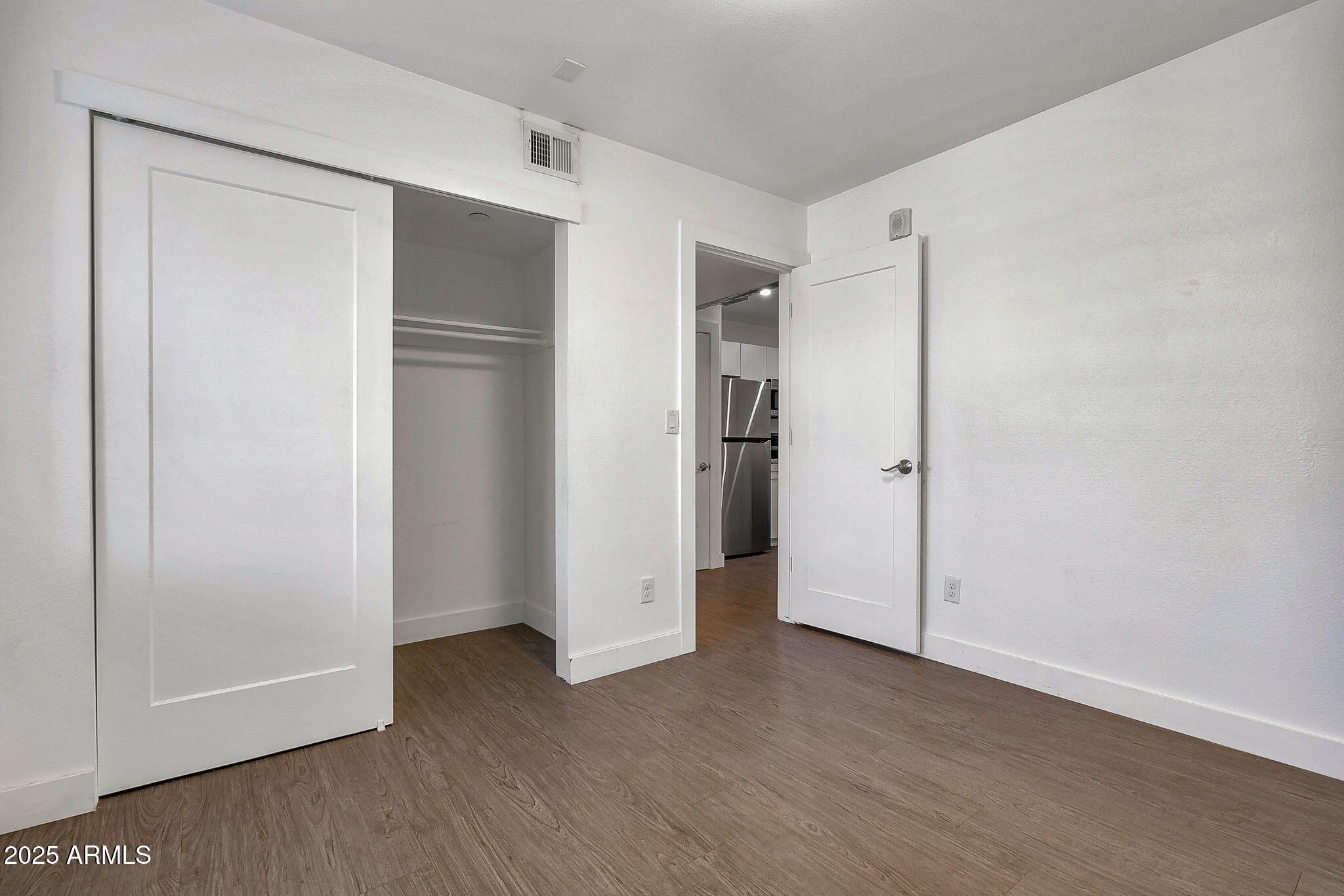 622 North 9th Avenue, Unit 101 Phoenix, AZ 85007 - Photo 14 of 18 a view of an empty room with closet and wooden floor