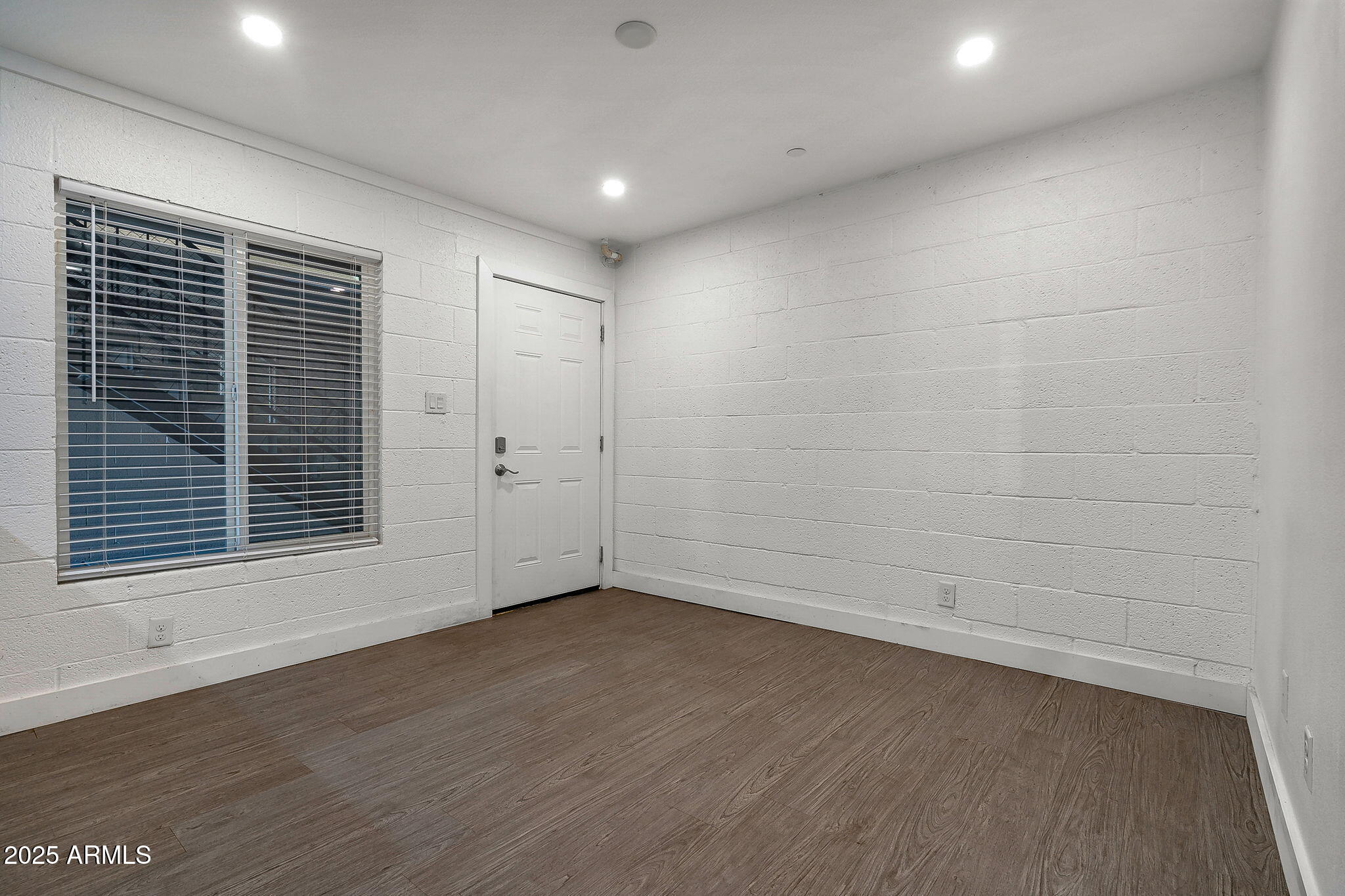 622 North 9th Avenue, Unit 101 Phoenix, AZ 85007 - Photo 5 of 18 a view of an empty room with wooden floor and a window
