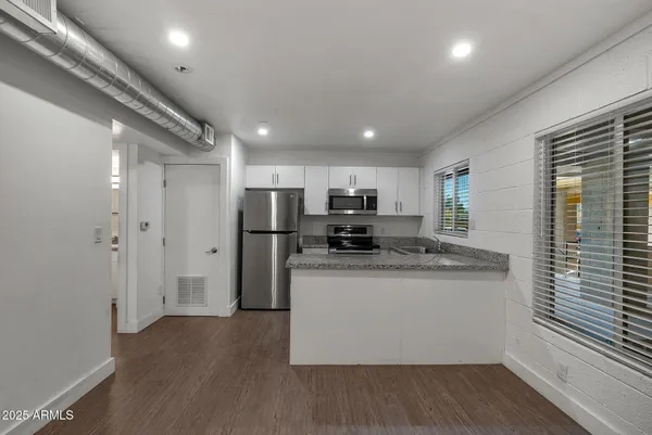 a kitchen with stainless steel appliances granite countertop a stove and a refrigerator