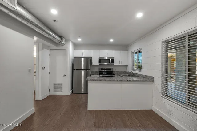a kitchen with stainless steel appliances granite countertop a stove and a refrigerator