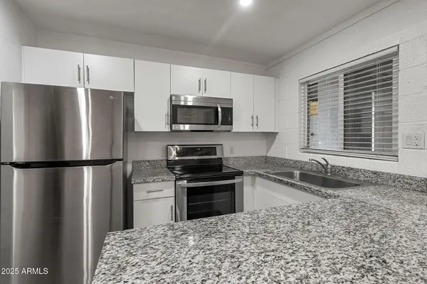 a kitchen with a refrigerator a microwave a sink and a stove