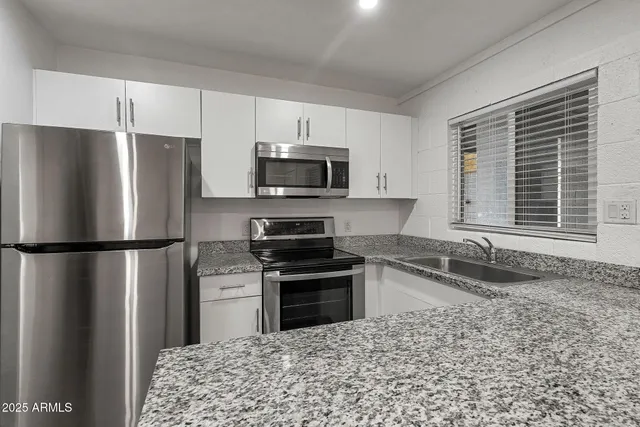 a kitchen with a refrigerator a microwave a sink and a stove