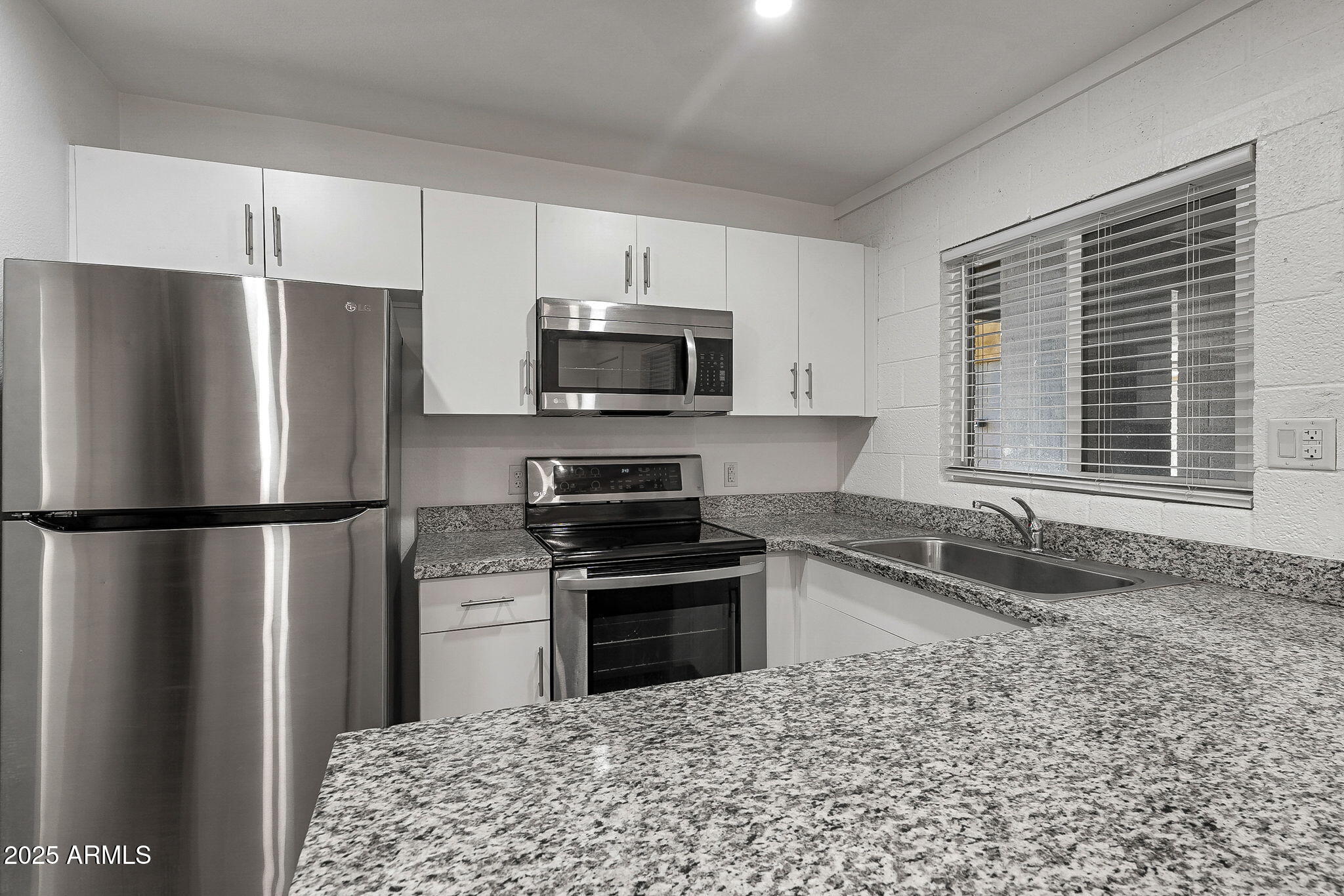 622 North 9th Avenue, Unit 101 Phoenix, AZ 85007 - Photo 9 of 18 a kitchen with a refrigerator a microwave a sink and a stove