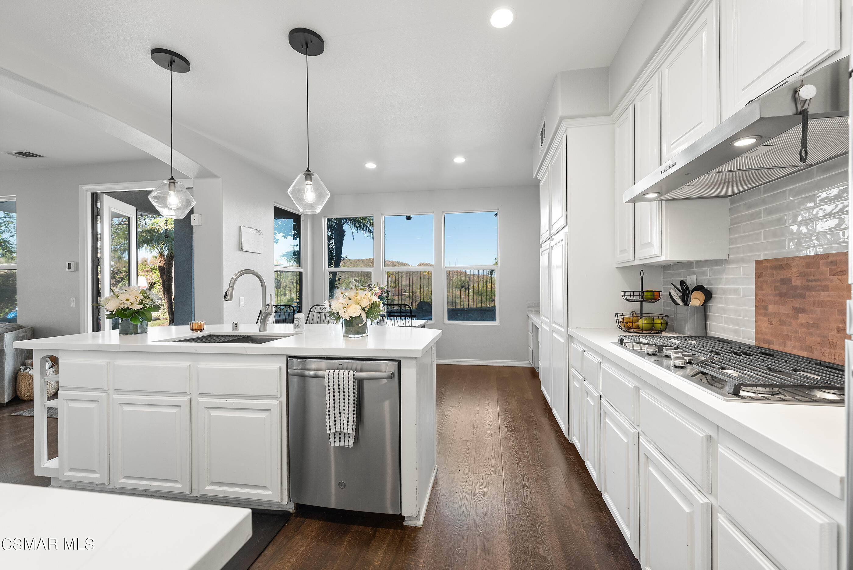 1997 Arielle Lane Simi Valley, CA 93065 - Photo 15 of 54 a kitchen with stainless steel appliances kitchen island granite countertop a stove a sink dishwasher and white cabinets with wooden floor