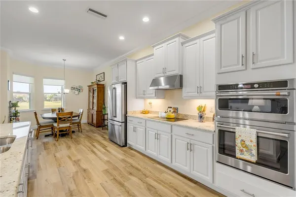 a kitchen with white cabinets and stainless steel appliances