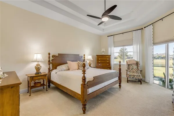 a bed sitting in a spacious bedroom next to a window