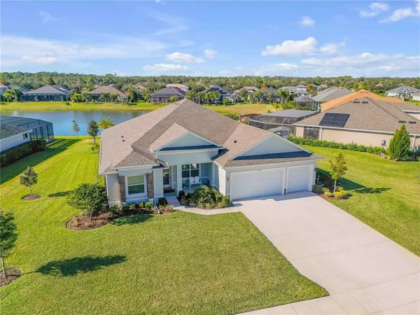 an aerial view of a house with a garden and lake view
