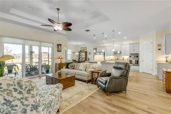 a living room with furniture kitchen view and a chandelier
