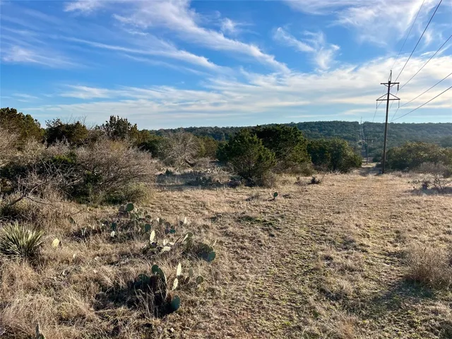 a view of a dry yard with wooden fence