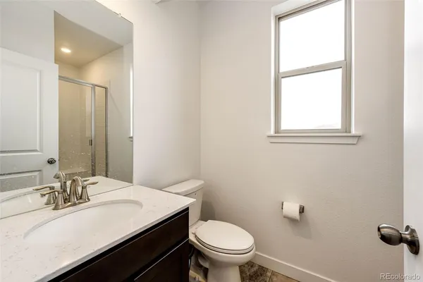 a bathroom with a sink vanity mirror and toilet