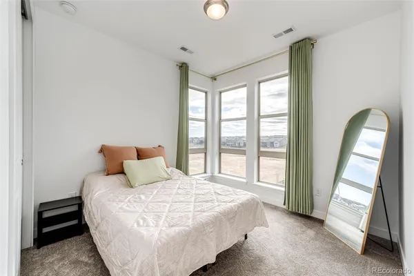 a bed sitting in a spacious bedroom next to a window