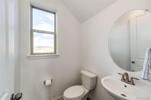 a bathroom with a sink mirror and toilet