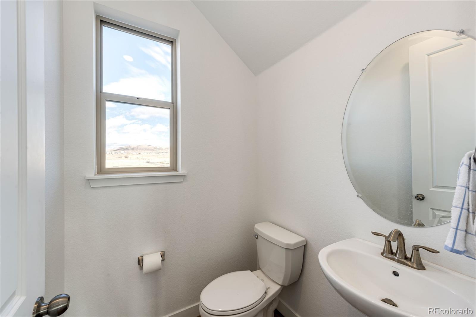 3100 South Russell Street Morrison, CO 80465 - Photo 22 of 29 a bathroom with a sink mirror and toilet