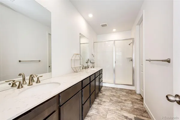 a bathroom with double vanity sink and a mirror