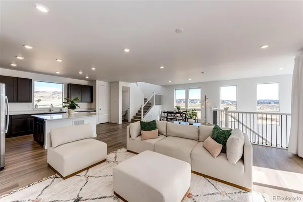 a living room with furniture kitchen view and a large window