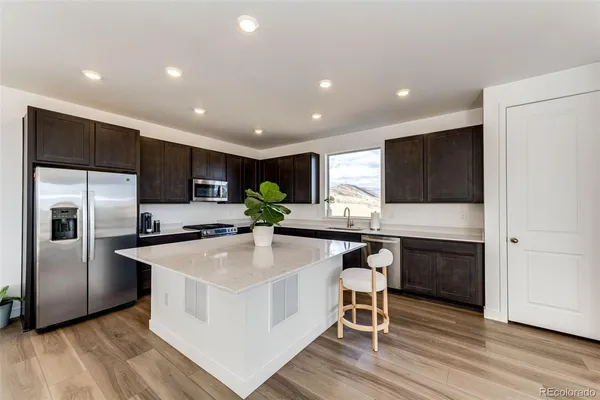 a kitchen with stainless steel appliances a microwave a stove a sink and a refrigerator