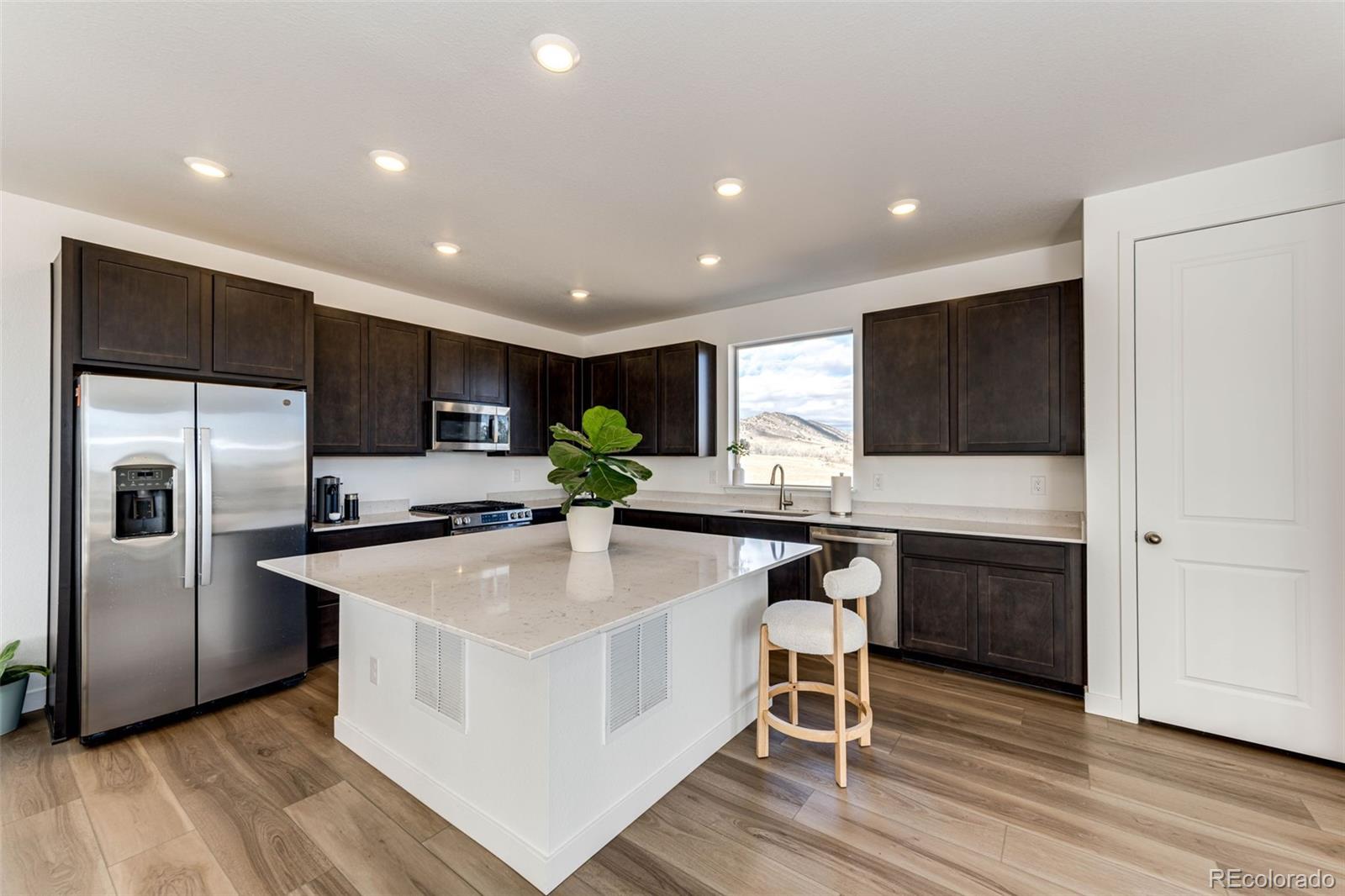3100 South Russell Street Morrison, CO 80465 - Photo 9 of 29 a kitchen with stainless steel appliances a microwave a stove a sink and a refrigerator