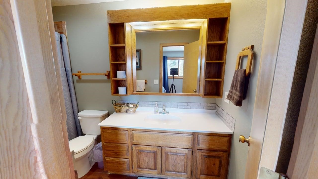 91200 Ryan Gulch Road, Unit 213 Silverthorne, CO 80498 - Photo 18 of 33 a bathroom with a sink toilet and mirror
