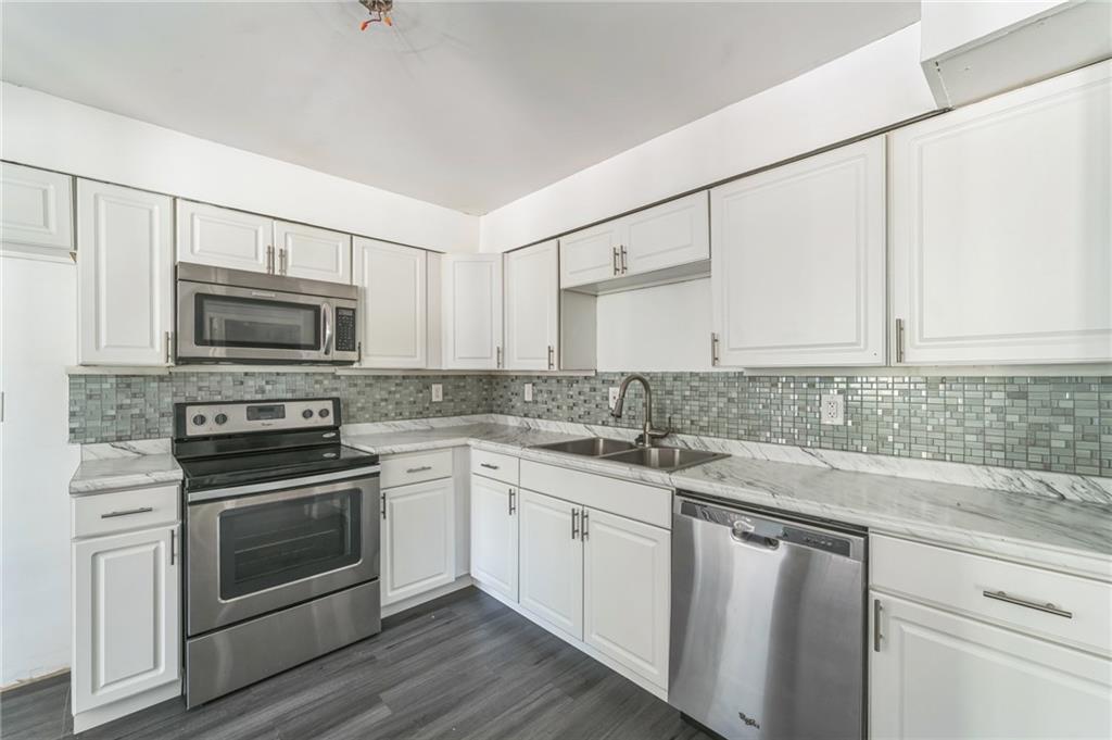 18 Quail Run, Unit A Decatur, GA 30035 - Photo 10 of 28 a kitchen with granite countertop white cabinets stainless steel appliances and a sink