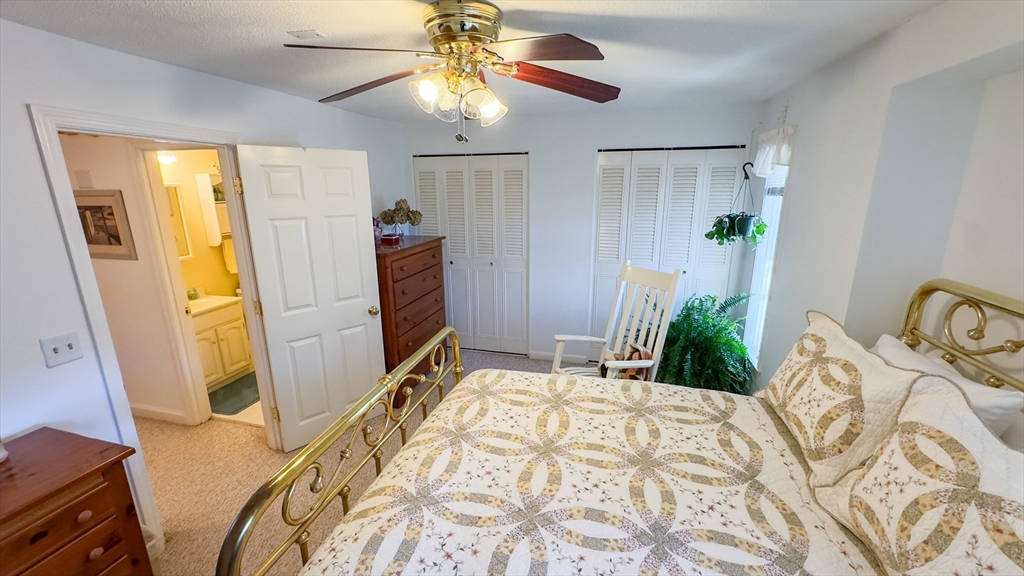 300 Buck Island Road, Unit 14F Yarmouth, MA 02673 - Photo 9 of 29 a bedroom with a bed and a chandelier