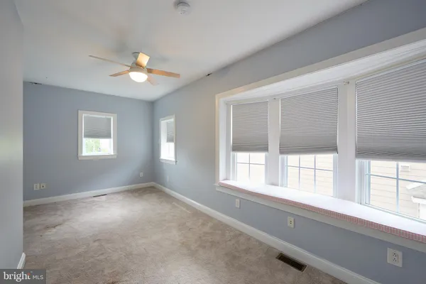 a view of room with window and a ceiling fan