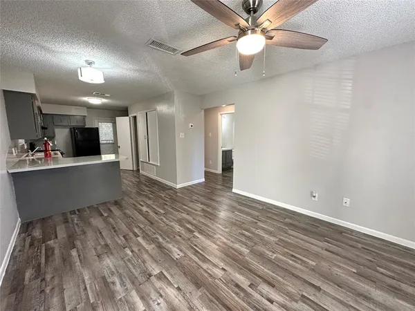 a view of a room with kitchen appliances and a ceiling fan