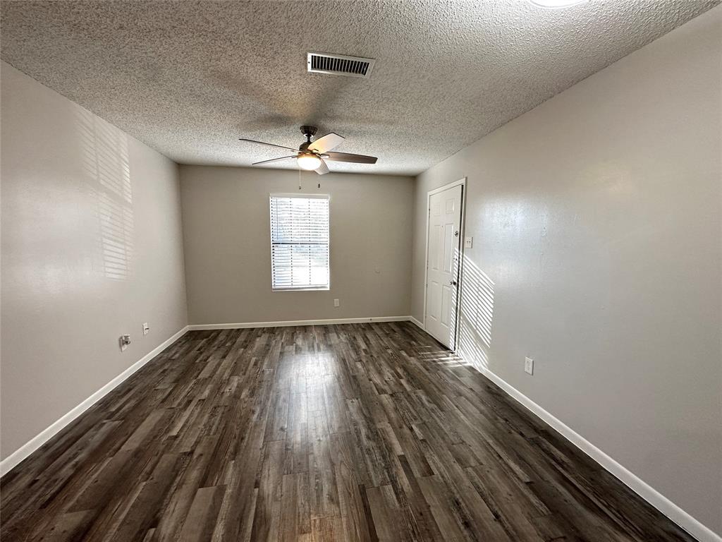2006 Jane Street, Unit H Longview, TX 75601 - Photo 4 of 12 wooden floor in an empty room with a window