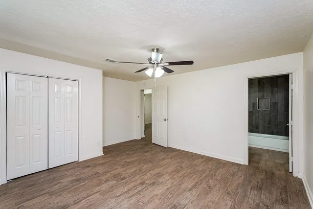 an empty room with a window and a fan
